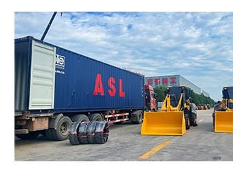 Wheel loaders next to a shipping container